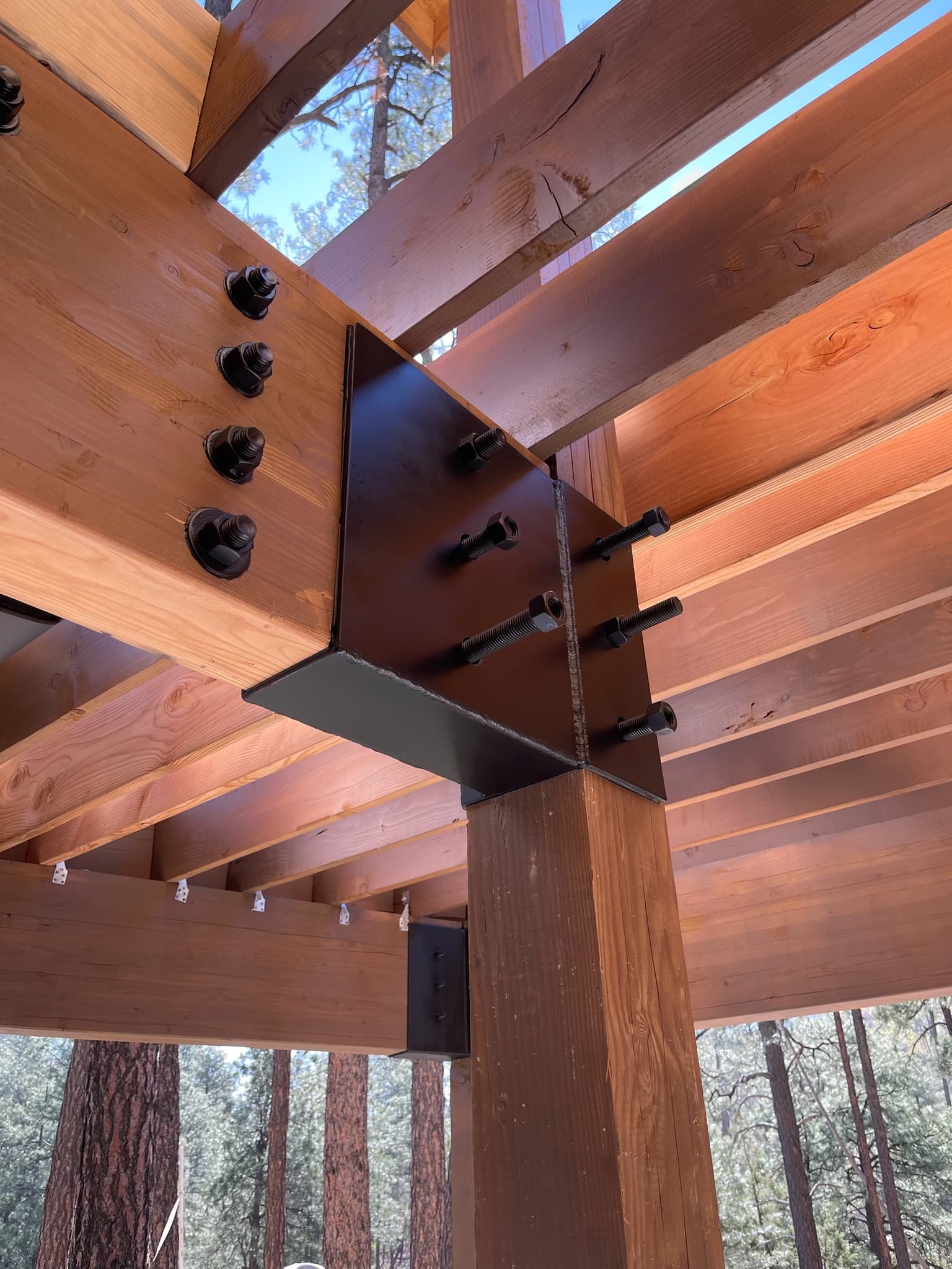 Custom welded steel bracket fabricated to fit a timber-framed log cabin in Prescott